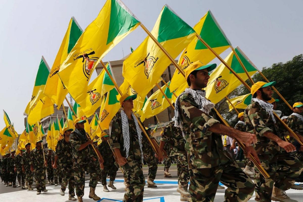 Kataib Hezbollah vẫy cờ của đảng khi họ đi dọc theo một con phố được sơn màu cờ Israel.