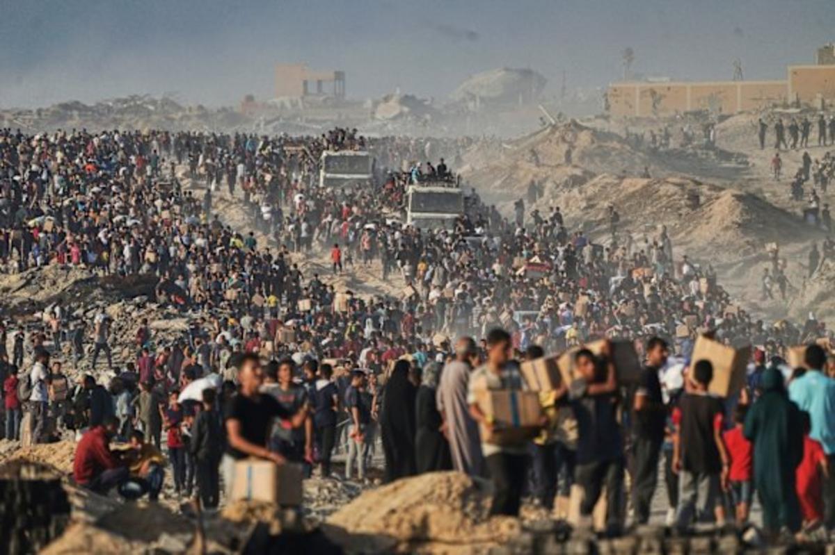 Người Palestine mang theo bao tải và thùng thực phẩm và viện trợ nhân đạo được dỡ xuống từ đoàn xe của Chương trình Lương thực Thế giới đã đến thành phố Gaza hồi đầu tuần.