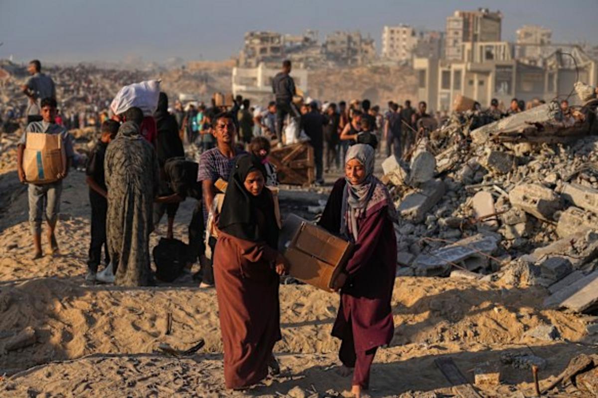 Người Palestine mang theo bao tải và thùng thực phẩm và viện trợ nhân đạo được dỡ xuống từ đoàn xe của Chương trình Lương thực Thế giới đã đến thành phố Gaza.